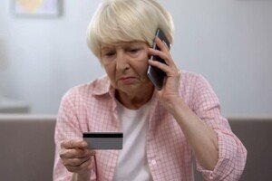 Altersarmut ist weiblich - ältere Dame besorgt am Telefon