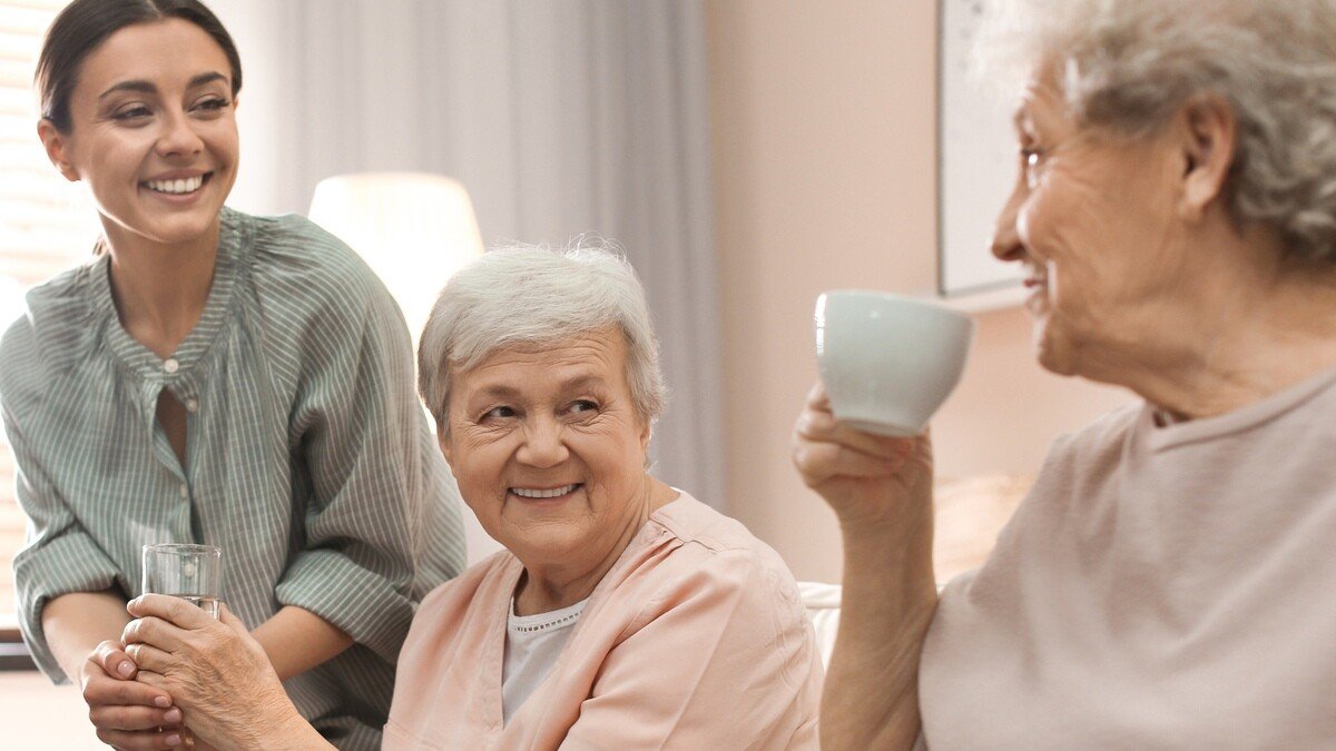 Altersarmut ist weiblich - 3 Frauen, zwei davon älter eine jünger, glücklich zusammen im Wohnzimmer