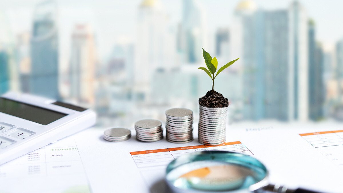 Grundbuch - Schreibtisch mit Münzen, Lupe und Notizen