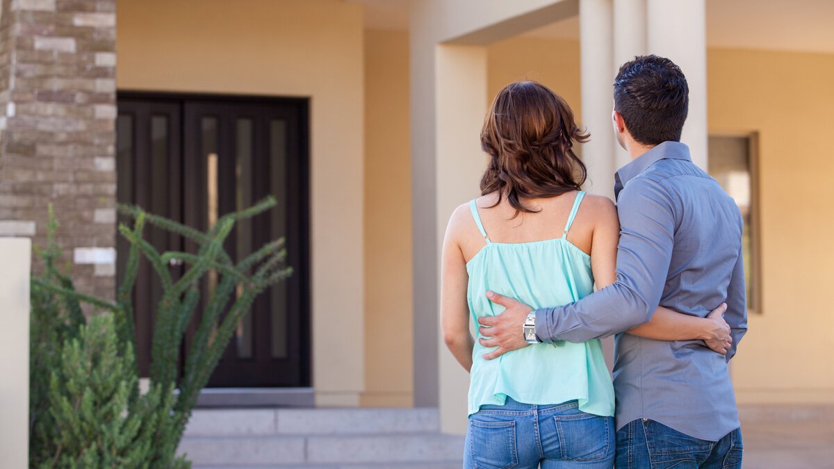 Notarkosten Hauskauf Notarkosten Hauskauf - junges Paar steht vor neu gekauftem Haus