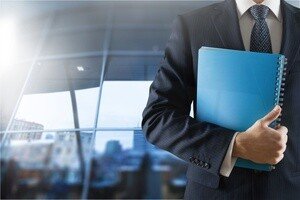 Notarkosten Hauskauf - Herr in Anzug, halb sichtbar steht in einem Büro