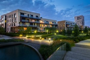 Betreten eines Nachbargrundstücks - Hochwertige moderne Wohnanlage mit beleuchtetem Garten bei Dämmerung