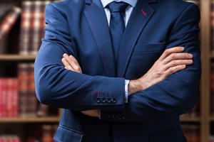 Bonitätsprüfung - Geschäftsmann vor Regalwand mit Gesetzesbüchern