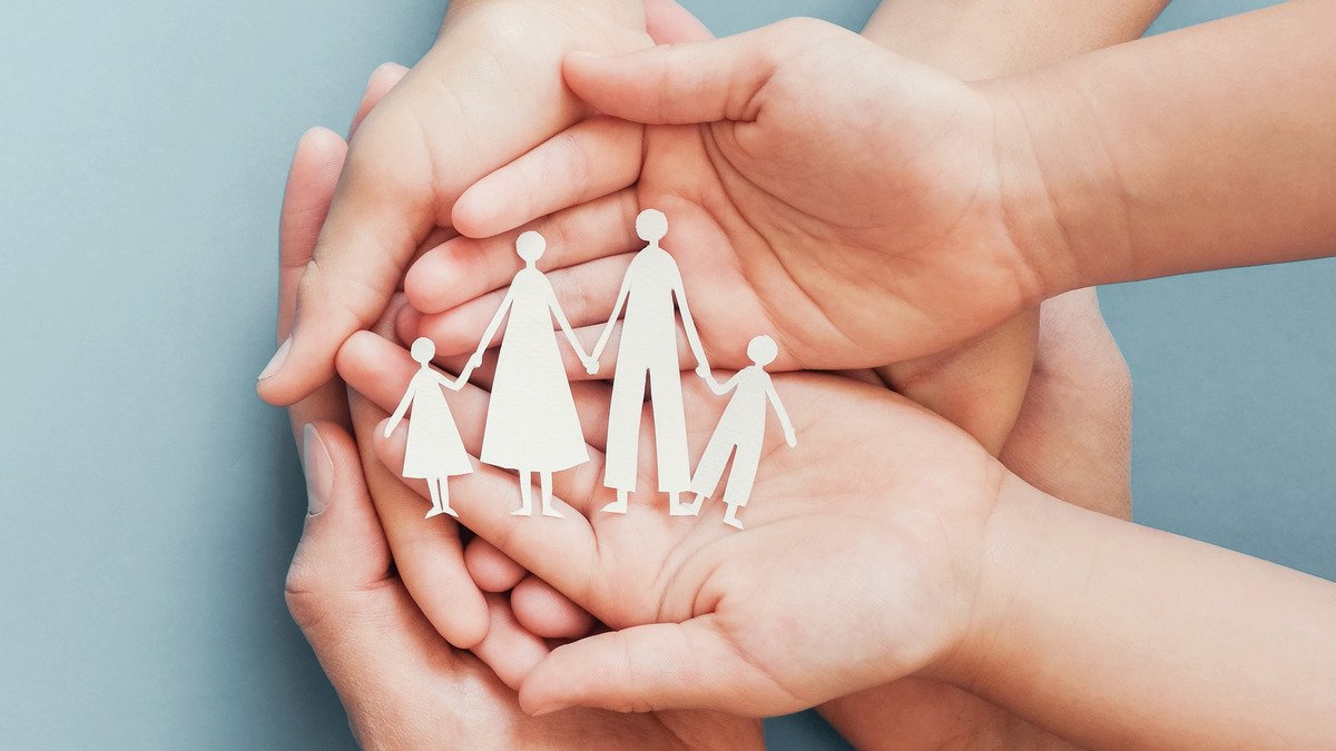 Erbengemeinschaft - Erwachsenen und Kinderhände halten ausgeschnittene Figuren einer Familie