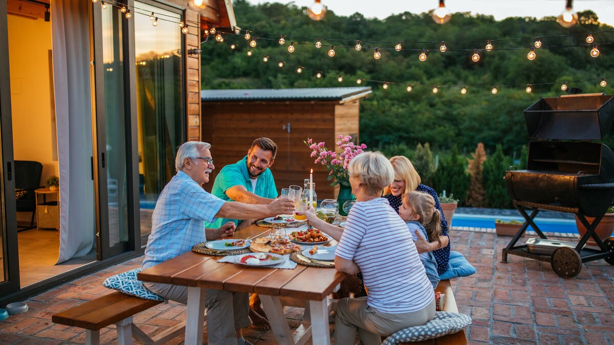 Erbengemeinschaft - Familie mit 3 Generationen beim Abendessen auf der Terasse