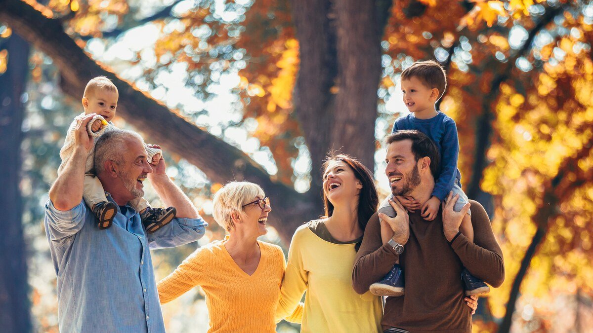Familie mit zwei Kindern geht gemeinsam durch einen Park