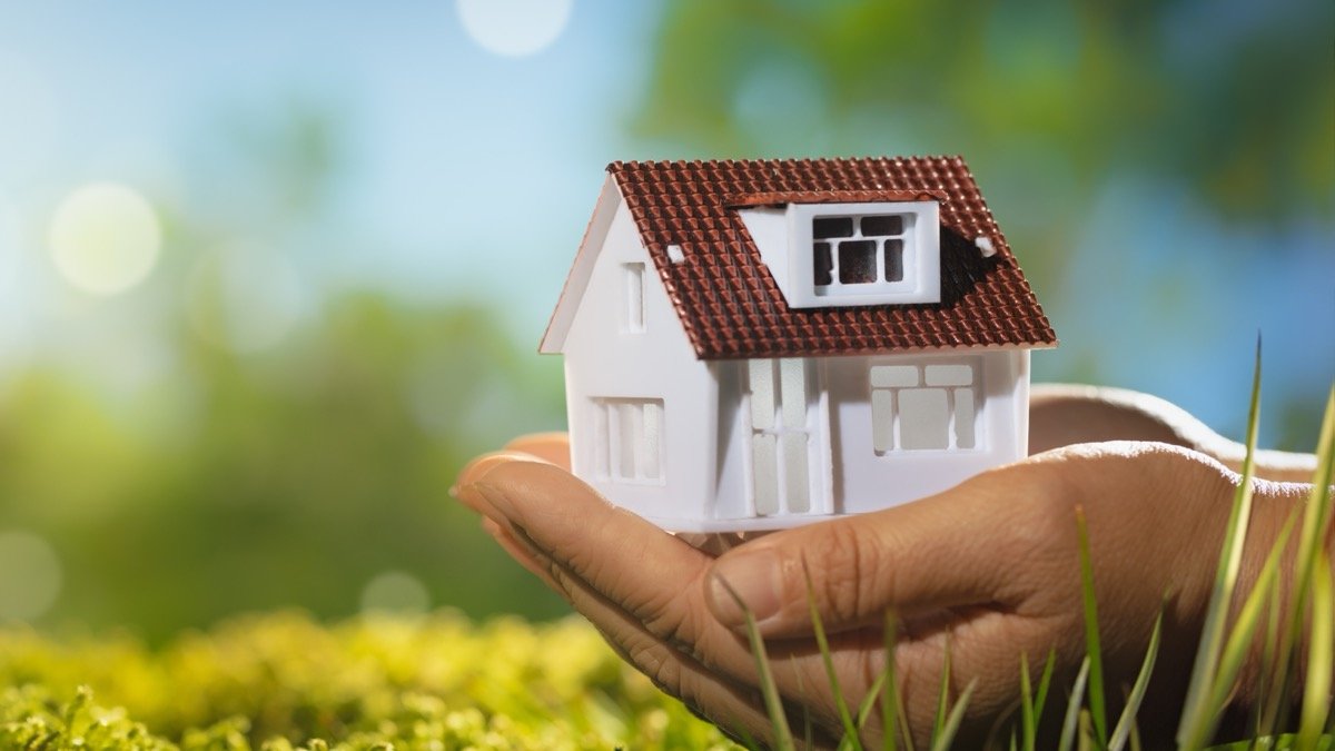 Erbteil verkaufen - Kleine Hausfigur liegt schÃ¼tzend in einer Hand