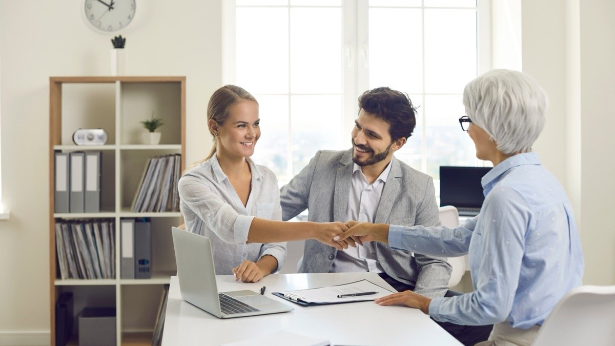 Erbschaftsteuer - Handschlag zwischen Ehepaar und Notar im Büro