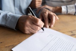 Erbschaftsteuer - Vertragsunterzeichnung am Schreibtisch