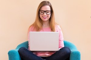 Frauen und Immobilien - Junge Frau sitzt mit Laptop vor Credit Score Anzeige