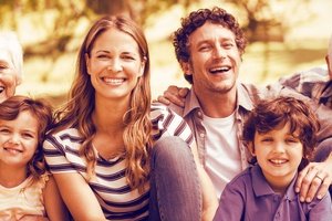 geerbte Immobilie verkaufen - Mehrgenerationenfamilie sitzt lachend gemeinsam im Freien