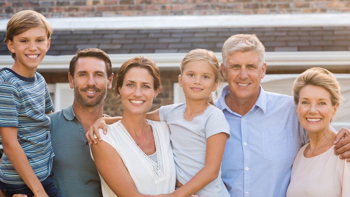 Immobilien als ErbschaftsvermÃ¶gen - glÃ¼ckliche Familie vor ihrem Haus