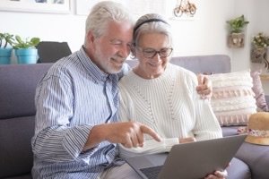 Immobilienteilverkauf Marktupdate 2026 - Seniorenpaar schaut gemeinsam auf Laptop im Wohnzimmer