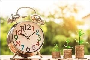 Uhr und wachsende Münzstapel als Symbol für Verjährungsfristen