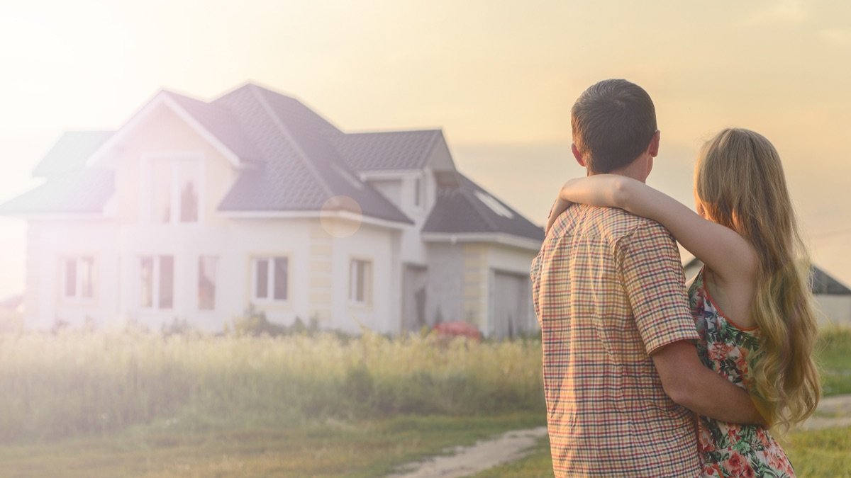 Ãlteres Paar vor einem Einfamilienhaus als Sinnbild fÃ¼r den Generationenwechsel am Immobilienmarkt