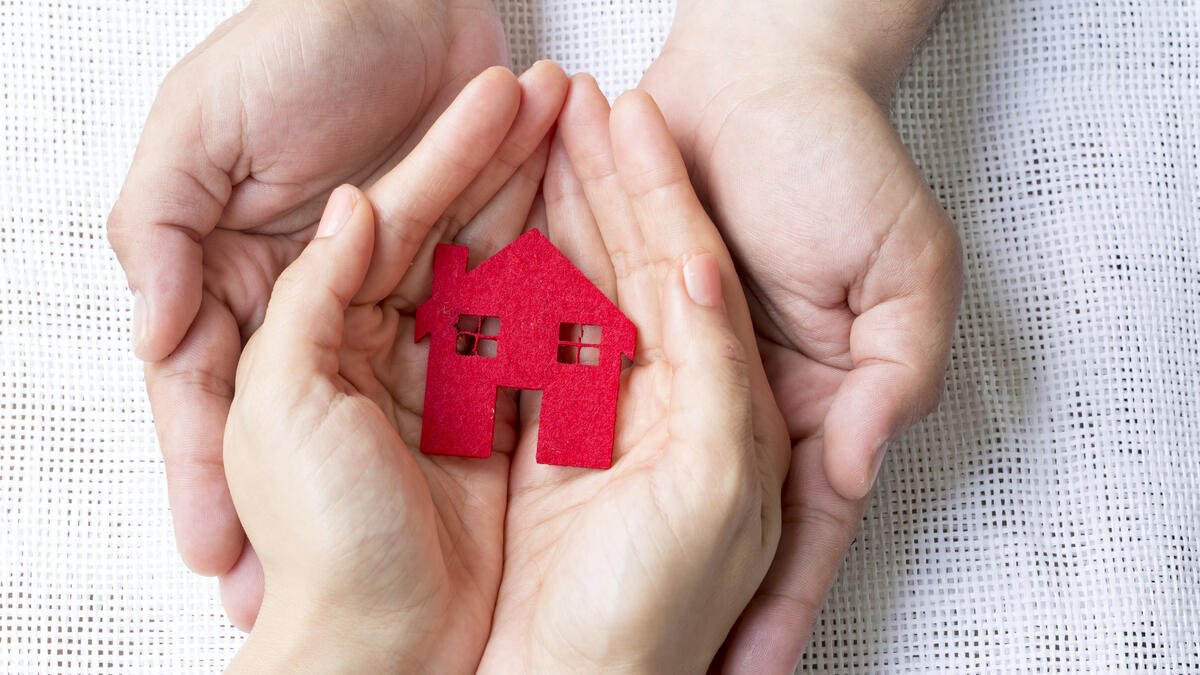 Wohnungsrecht: Modellhaus wird in 2 Paar Händen gehalten